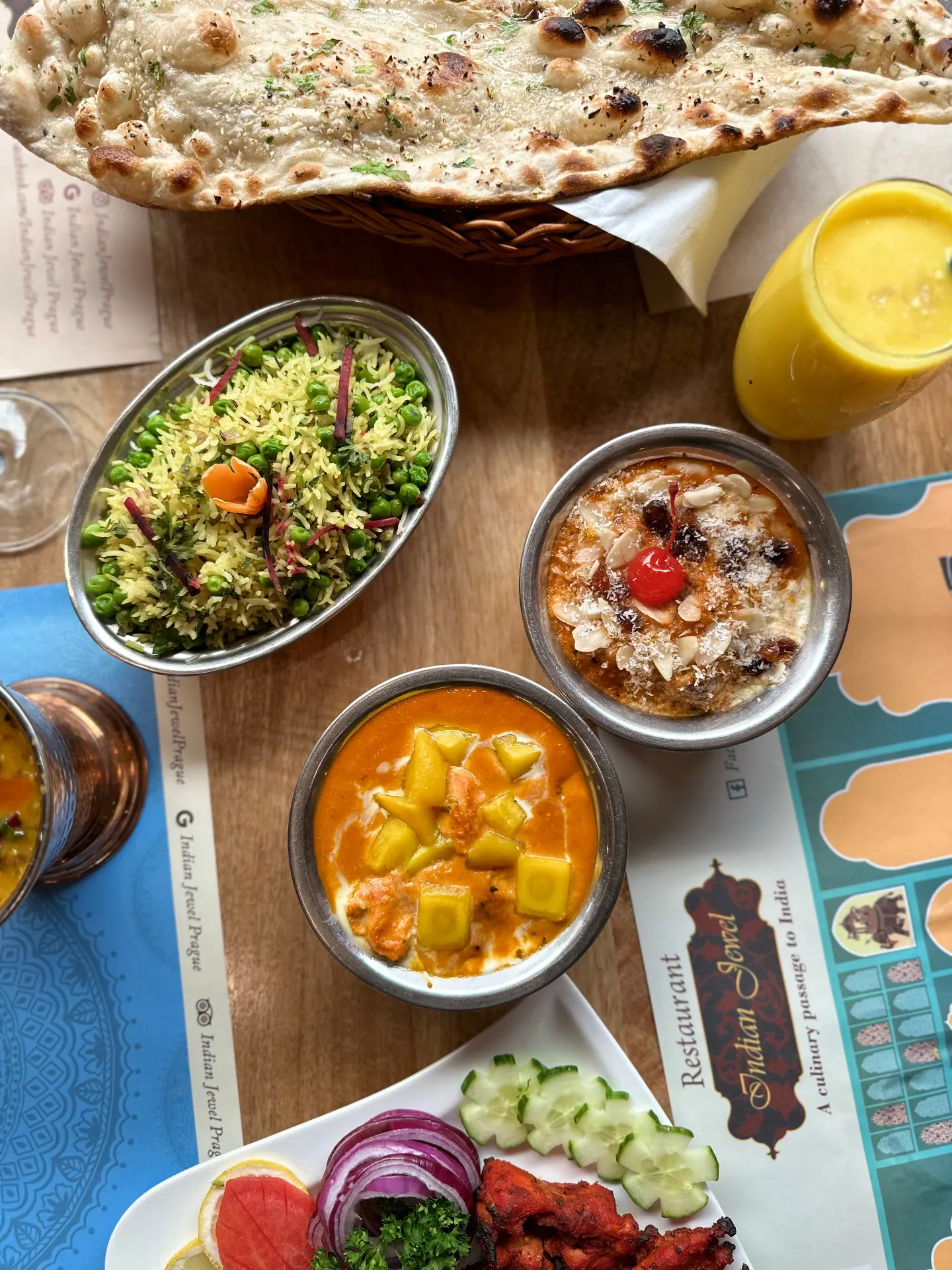 A table at Indian Jewel, Prague: naan, peas pulao, paneer curry, kheer, mango lassi and tandoori chicken